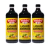 3 bottles of bragg's liquid aminos soy protein seasoning front view angle